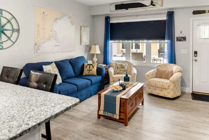 Open living room & kitchen, with mounted smart TV, Dining table, strong WiFi, sleeper sofa and fully-equipped kitchen