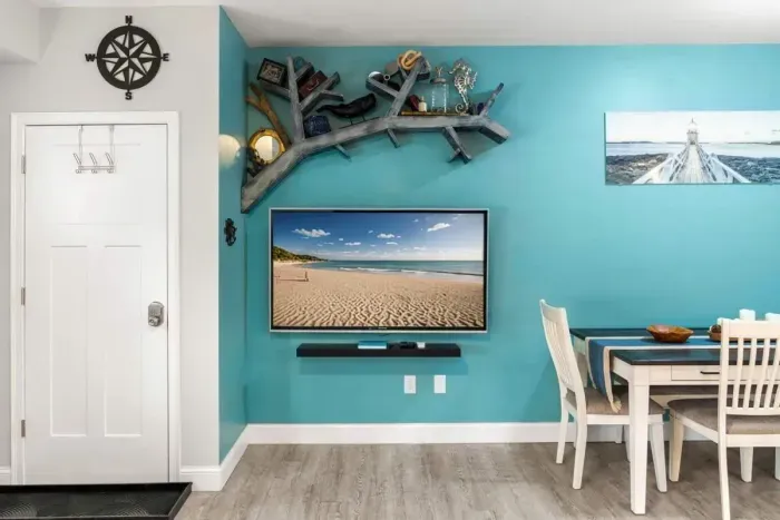 Open living room & kitchen, with mounted smart TV, Dining table, strong WiFi, sleeper sofa and fully-equipped kitchen