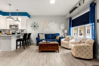 Open living room & kitchen, with mounted smart TV, Dining table, strong WiFi, sleeper sofa and fully-equipped kitchen