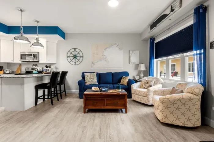 Open living room & kitchen, with mounted smart TV, Dining table, strong WiFi, sleeper sofa and fully-equipped kitchen