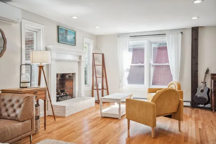 The family room with two chairs, and two comfy couches. There is a smart tv and Sonos sound system in this room. (Fireplace is not operational)