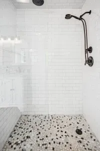 The primary bedroom ensuite with tiled shower, double vanity, and provided clean towels