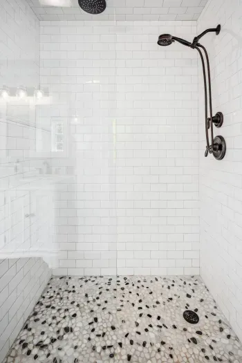 The primary bedroom ensuite with tiled shower, double vanity, and provided clean towels