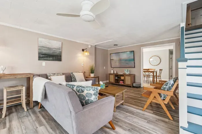 Back unit living room featuring a large sectional couch, smart TV with the ability to log into personal streaming platforms, and shuffle board!