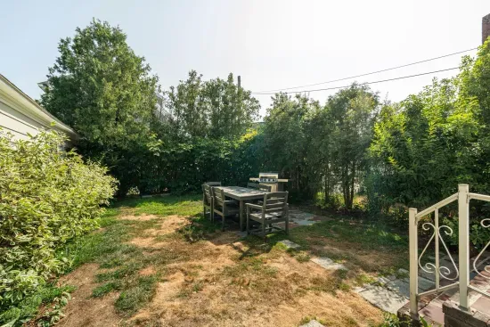 Spacious backyard with patio, dining table, and gas grill