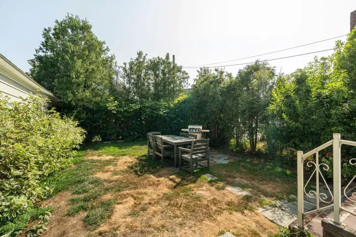 Spacious backyard with patio, dining table, and gas grill
