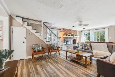 Back unit living room featuring a large sectional couch and smart TV with the ability to log into personal streaming platforms. Note: Fireplace is inoperable. There is a shuffleboard table here too!