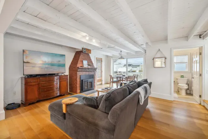The main living area - with a cozy breakfast nook overlooking the deck, comfy couch with a large smart TV, and gas fireplace. There is seating for 4 at the bar in addition