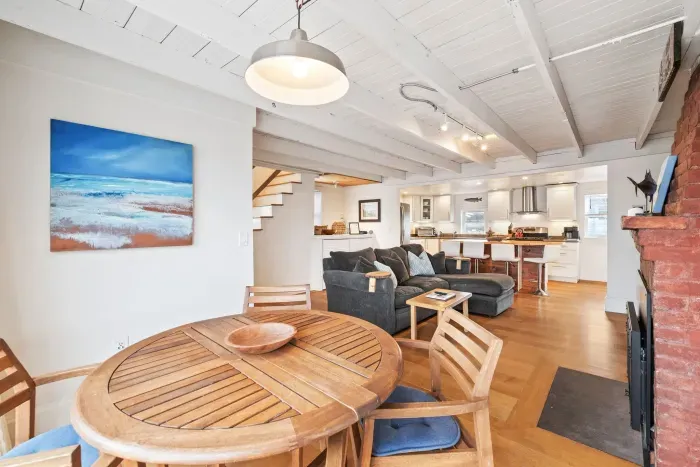 The main living area - with a cozy breakfast nook overlooking the deck, comfy couch with a large smart TV, and gas fireplace