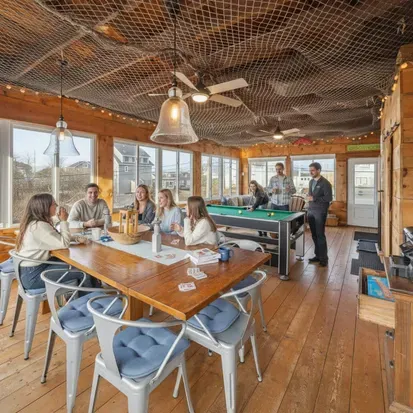 The closed in porch - this area is heated and cooled with it's own mini-split system. There is a pool/air hockey table, seating for 10 at the table, and another seating area with a sectional and chairs