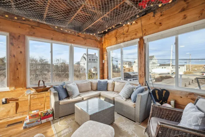 The closed in porch - this area is heated and cooled with it's own mini-split system. There is a pool/air hockey table, seating for 10 at the table, and another seating area with a sectional and chairs