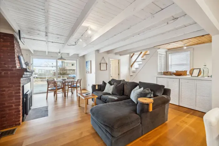 The main living area - with a cozy breakfast nook overlooking the deck, comfy couch with a large smart TV, and gas fireplace. There is seating for 4 at the bar in addition. The laundry is located in the half closet shown behind the couch