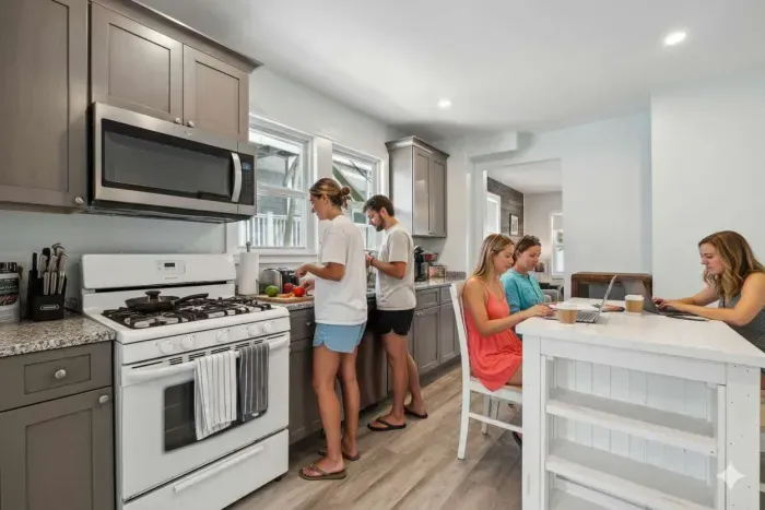 Fully equipped kitchen with updated appliances, washer/dryer unit, and 4-person dining table