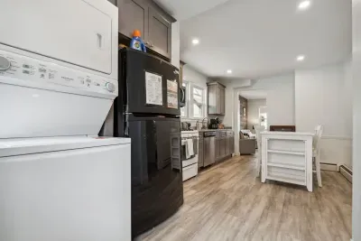 Fully equipped kitchen with updated appliances, washer/dryer unit, and 4-person dining table