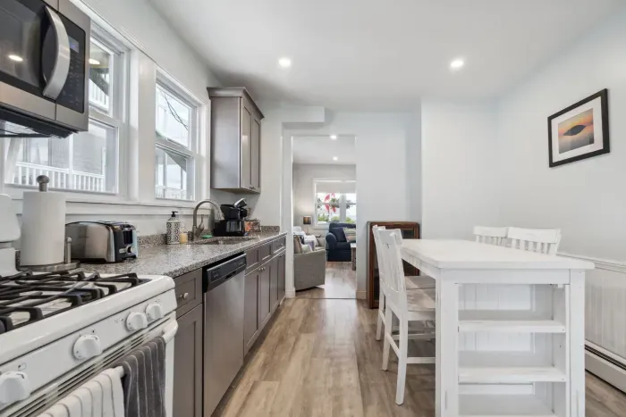 Fully equipped kitchen with updated appliances, washer/dryer unit, and 4-person dining table