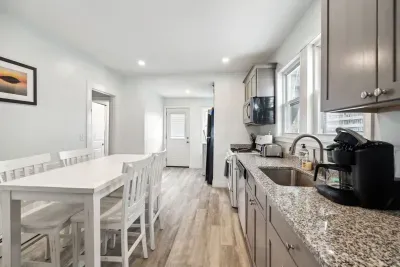 Fully equipped kitchen with updated appliances, washer/dryer unit, and 4-person dining table