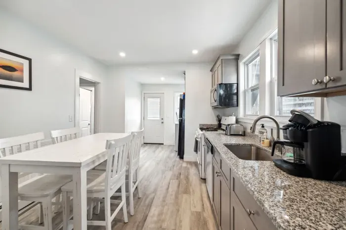 Fully equipped kitchen with updated appliances, washer/dryer unit, and 4-person dining table