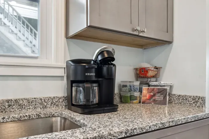 Fully equipped kitchen with updated appliances, washer/dryer unit, and 4-person dining table