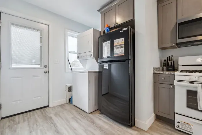 Fully equipped kitchen with updated appliances, washer/dryer unit, and 4-person dining table