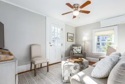 Cozy living room with comfy couch and chairs, and a smart TV. Access to the front balcony is from this room.