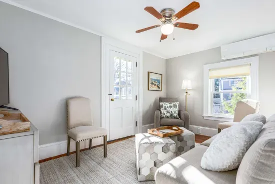 Cozy living room with comfy couch and chairs, and a smart TV. Access to the front balcony is from this room.