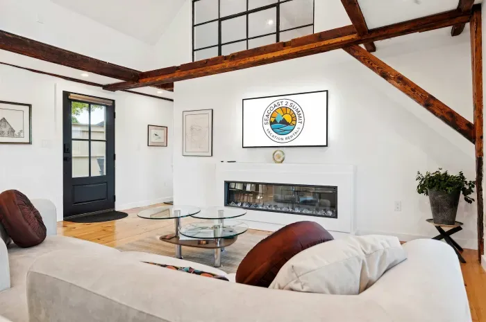 Living room features an spacious sectional, electric fireplace, and smart TV. There are also river views.