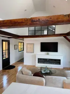 Small sectional couch in the living room featuring a smart TV and electric fireplace.