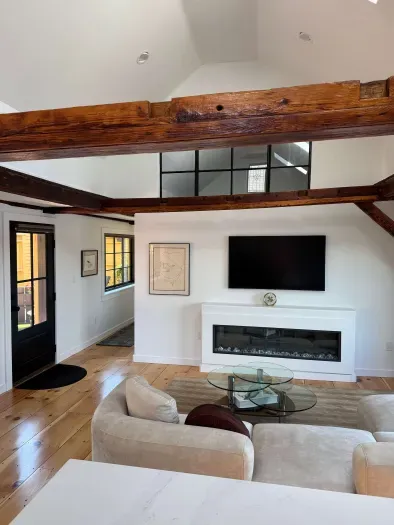 Small sectional couch in the living room featuring a smart TV and electric fireplace.