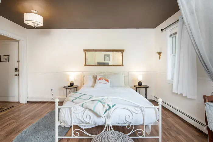 The Bridgewater Inn Main House - Serene Bedroom featuring Crisp White Linens & Warm Industrial Lighting