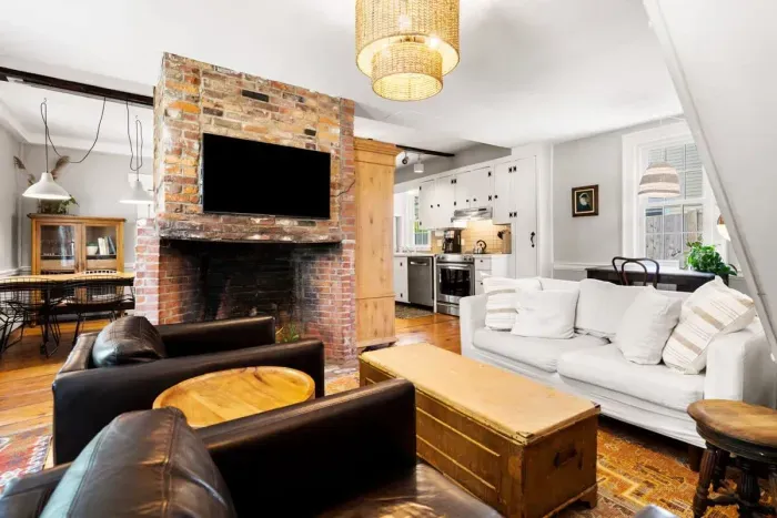 Living room with smart TV, couch, accent chairs and dedicated "work-from-home" desk. The fireplace is inoperable.