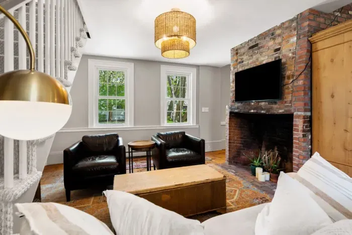 Living room with smart TV, couch, accent chairs and dedicated "work-from-home" desk. The fireplace is inoperable.