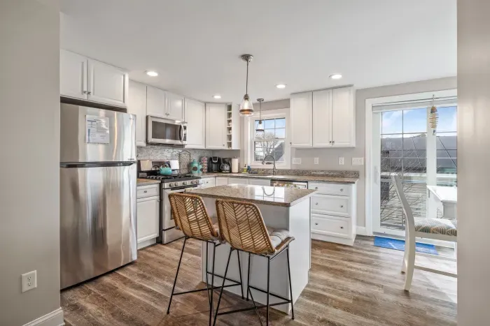 Fully equipped kitchen with updated appliances, coffee provided, and an island with seating for two.