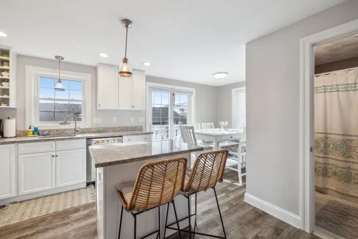 Fully equipped kitchen with updated appliances, coffee provided, and an island with seating for two.