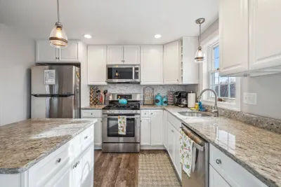 Fully equipped kitchen with updated appliances, coffee provided, and an island with seating for two.