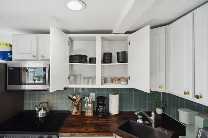 Fully stocked kitchen with a kettle, coffee maker, essential utensils, and cookware—ready for all your meal prep needs!