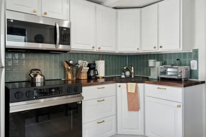 Fully stocked kitchen with a kettle, coffee maker, essential utensils, and cookware—ready for all your meal prep needs!