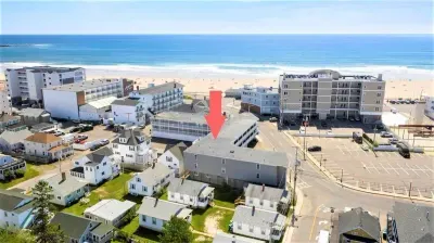 Aerial view of building, steps to beach and boardwalk.