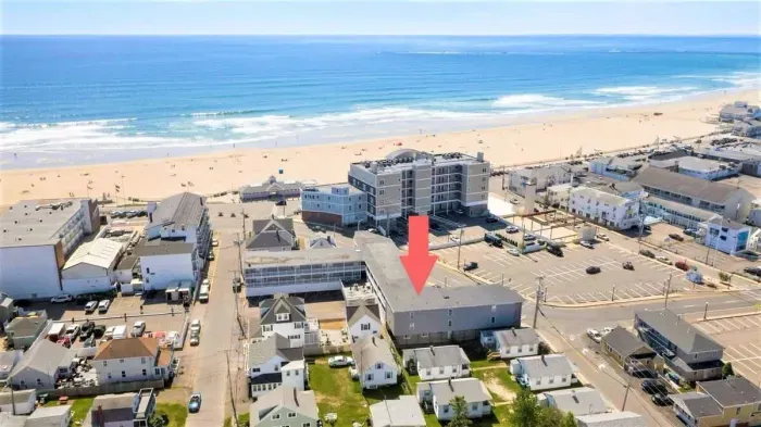 Aerial view of building, steps to beach and boardwalk.