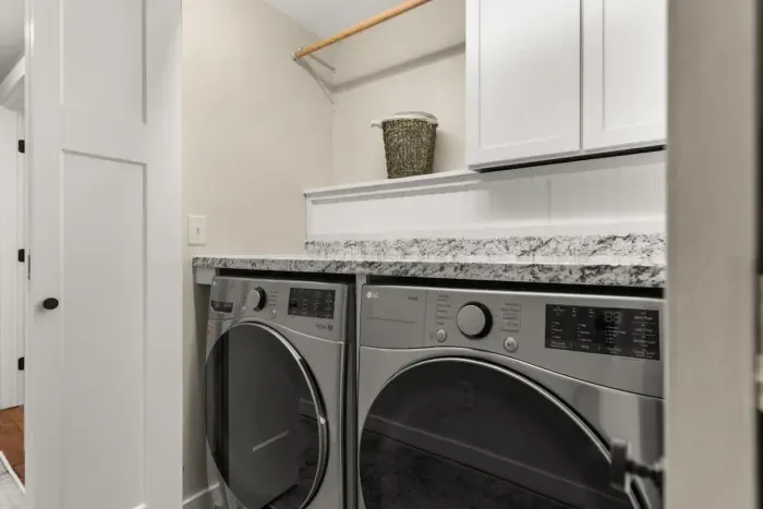 Washer and dryer located in the hallway between the first and second bedrooms on the first level of the house.