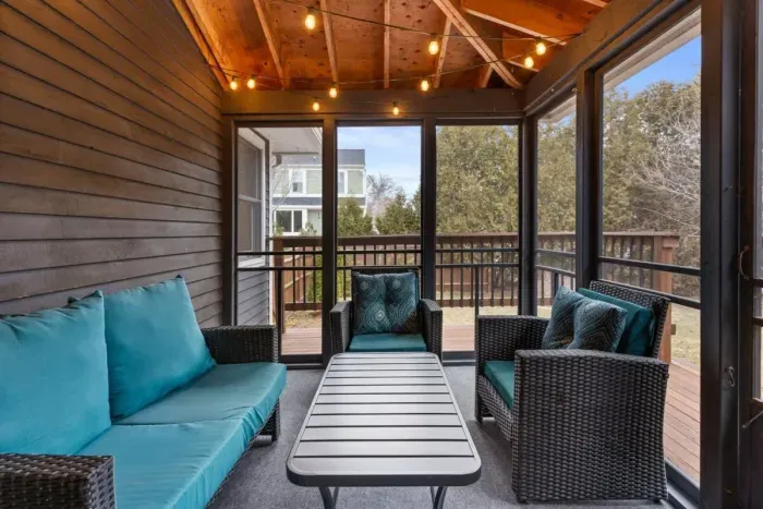 Fully enclosed, cozy and bright 3-season porch, with a rustic yet modern feel.