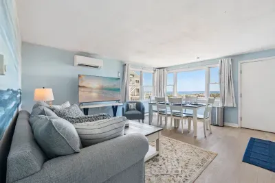Fully equipped open kitchen, dining, and living room with a large Smart TV.