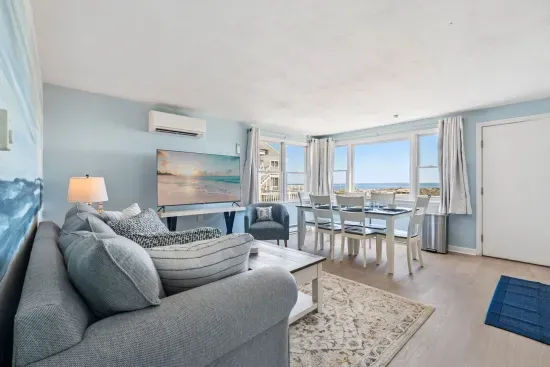 Fully equipped open kitchen, dining, and living room with a large Smart TV.