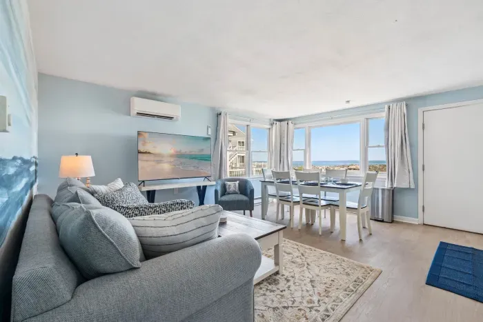 Fully equipped open kitchen, dining, and living room with a large Smart TV.