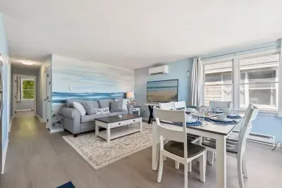 Fully equipped open kitchen, dining, and living room with a large Smart TV.