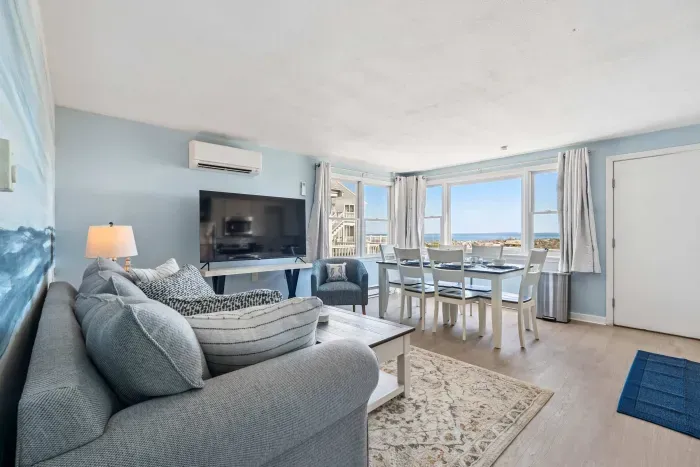 Fully equipped open kitchen, dining, and living room with a large Smart TV.