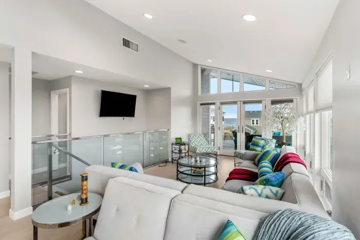 Living area with large sectional couch, smart TV, ocean views, and a gas fireplace!