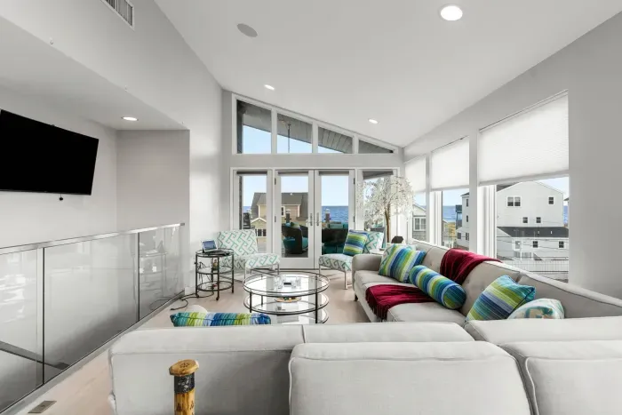 Living area with large sectional couch, smart TV, ocean views, and a gas fireplace!