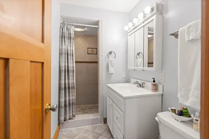 The downstairs bathroom in the Yoga unit with a standing shower. Clean towels provide for all guests