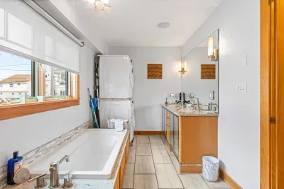 The second bathroom in the Yoga unit with a stacked washer and dryer, soaking tub and tiled shower! Clean towels provided for all guests.