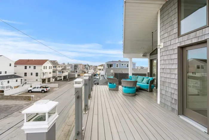 Rooftop deck with ocean views, outdoor furniture, and access to the living room and primary bedroom. 